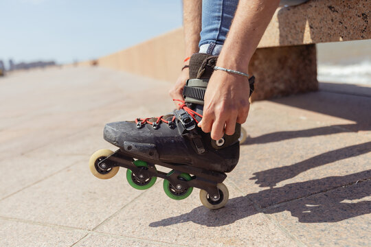 Young man fitting inline skates outdoors