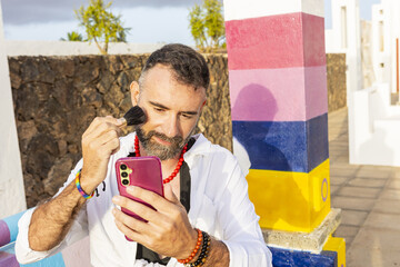 Transvestite gay man applying makeup outdoors