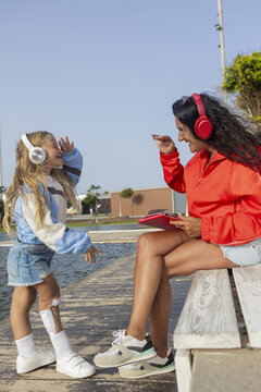 Girl with disability and her mom enjoying music outdoors