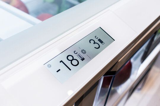 Modern kitchen fridge temperature display and visible fruits