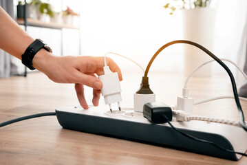 Person is plugging in a device to a power strip
