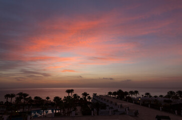 Sunrise on the sea coast. The movement of the sun and clouds across the sky. Park recreation areas of Egypt. Garden and landscape design.