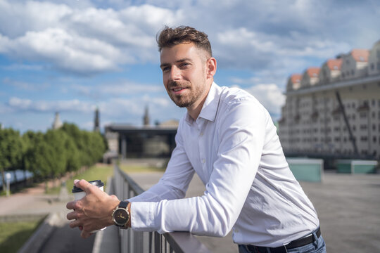 Men in formal white attire posing in sunlight