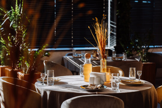 Sunlit restaurant table with elegant glassware, decor, and a warm, cozy ambiance