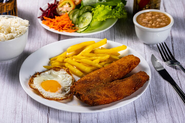 breaded chicken with eggs, fries and vegetables