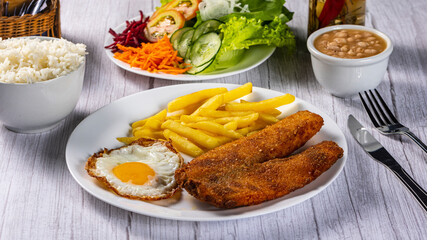 breaded chicken with eggs, fries and vegetables