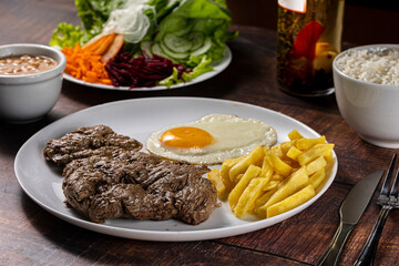 grilled steak with fries, rice and egg