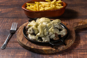 grilled meat with cheese topping and fries