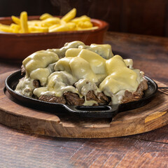grilled meat with cheese topping and fries