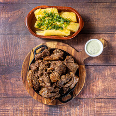 pieces of grilled meat with cassava