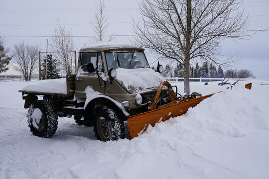 unimog snow plow removing snow from a driveway after a blizzard in Cheyenne wyoming