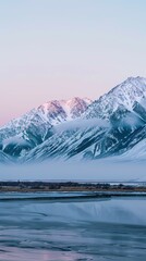 Serene snow-covered mountains reflecting soft pink and blue hues of dawn over a misty valley and calm frozen landscape