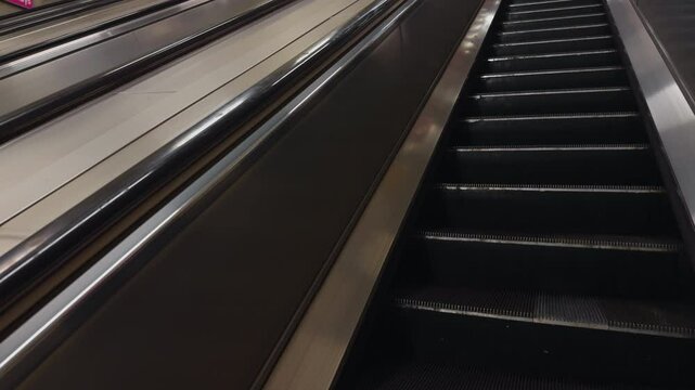 A captivating escalator view features empty steps alongside a red object moving in dynamic motion within the space