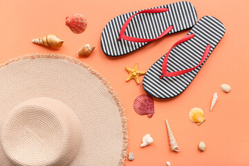 Beautiful seashells, flip-flops and hat on orange background. Summer concept
