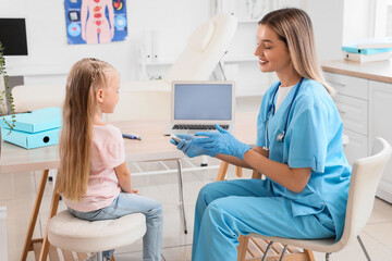 Female endocrinologist with glucometer and little girl in clinic