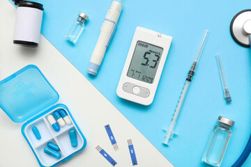 Glucometer with lancet pen, insulin and pills on color background. Diabetes concept