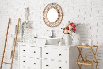 Vase with beautiful dahlia flowers near sink in stylish light bathroom