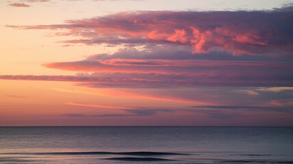 Obraz premium Pink and Purple Sunset Clouds over Calm Ocean