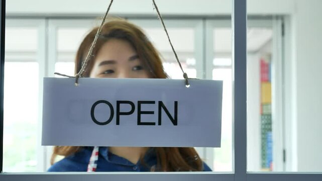 Woman hands turning sign board closed to open shop small local retail business. Happy Asian woman smiling face reopen shop again with service mind. Small owner turn sign plaboard welcome opening shop