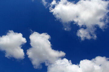 Fototapeta premium Blue sky with fluffy white clouds scattered across it