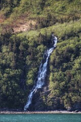 Cascading Waterfall Flowing Down a Lush Green Mountainside in Alaska