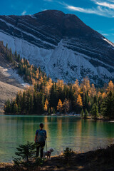 Backpacker girl and her dog,  Admiring Autumn Splendor at Chester Lake Alberta Canada Kananaskis Park