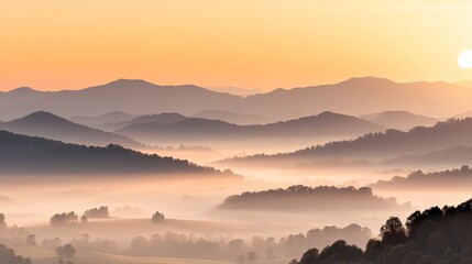 Obraz premium A serene landscape at dawn, featuring rolling hills shrouded in mist with a warm, glowing sunrise illuminating the scene.
