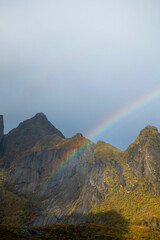 A rainbow appearing amidst beautiful mountains.