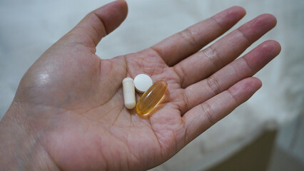 Woman hands take multivitamins, there are omega 3, zinc and vitamin D3 High Dose. Vitamin Consumption Routine.