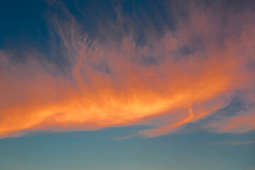 sunset. dark blue sky in the evening with fluffy orange clouds.