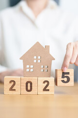 Happy New Year 2025 with house model. real estate, Home loan and mortgage, tax, investment,...