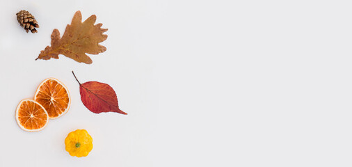 Autumn holiday frame composition with pattern made of leaf, punpkins, dried orange, pine cone on...
