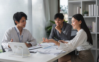 Obraz premium Asian Business Team Meeting for Idea Exchange and Discussion in Modern Office Setting