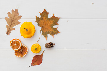 Autumn holiday frame composition with pattern made of leaf, punpkins, dried orange, pine cone on...