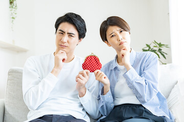 財布を持ち考えるカップル