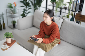 Young Asian woman gamer controller video console playing holding hobby playful Online Video Game...