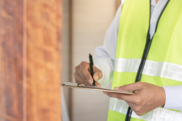 inspector or engineer is inspecting construction and quality assurance new house using a checklist. Engineers or architects or contactor work to build the house before handing it over to the homeowner