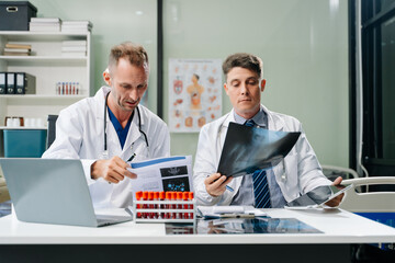 Doctors analyzing an X-ray, collaborating with digital tools in a medical office. Showcasing teamwork, diagnostic