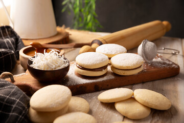 Alfajor. A traditional dessert popular in Latin American, it consists of two cookies joined together with dulce de leche forming a sandwich, covered with powdered sugar, grated coconut or chocolate.