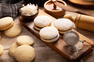 Alfajor. A traditional dessert popular in Latin American, it consists of two cookies joined together with dulce de leche forming a sandwich, covered with powdered sugar, grated coconut or chocolate.