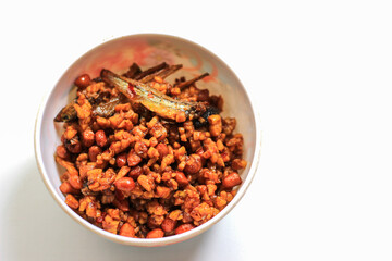 Indonesian dish dried tempeh, made from tempeh or soybeans cut into small pieces, cooked with chili, soy sauce and anchovies, isolated on white background