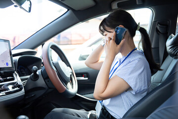 車の事故で電話で警察を呼ぶ女性　
A woman calls the police on the phone after a car...