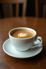 Obraz premium Сup of coffee on a wooden table in a coffee shop.