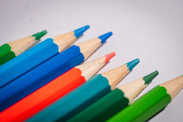 Obraz premium A row of pencils with different colors, including blue, green, and red