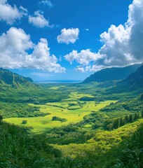 Obraz premium A panoramic view of a lush green valley with mountains in the background and the ocean in the distance. The sky is blue with white clouds.