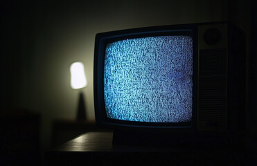 Old vintage television isolated on dark background with no signal and grainy noise