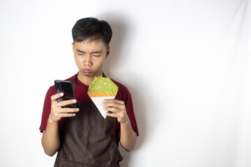 Teen bartender who is surprised with his cellphone also holds snacks