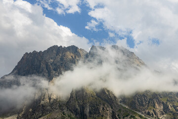 Rocky vertical cliffs surrounded by clouds in the wilderness of Ala Archa national park