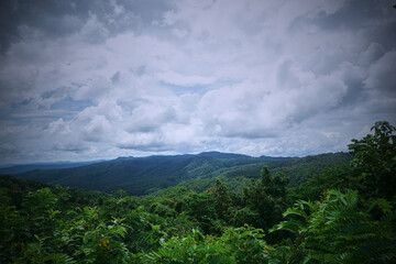Obraz premium A stunning view of lush green hills under a cloudy sky.