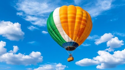 Obraz premium Colorful Hot Air Balloon Soaring Through Blue Sky with White Clouds